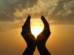 Zwei Hände mit der Sonne in der Mitte